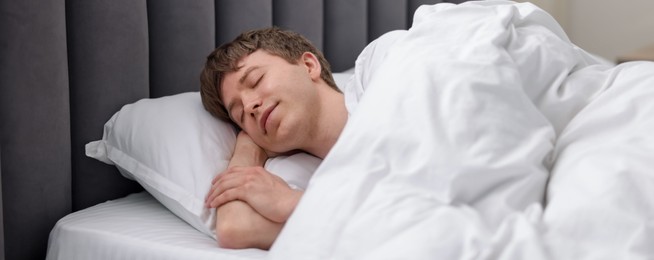Photo of Young man sleeping in bed at home