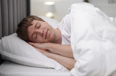 Photo of Young man sleeping in bed at home