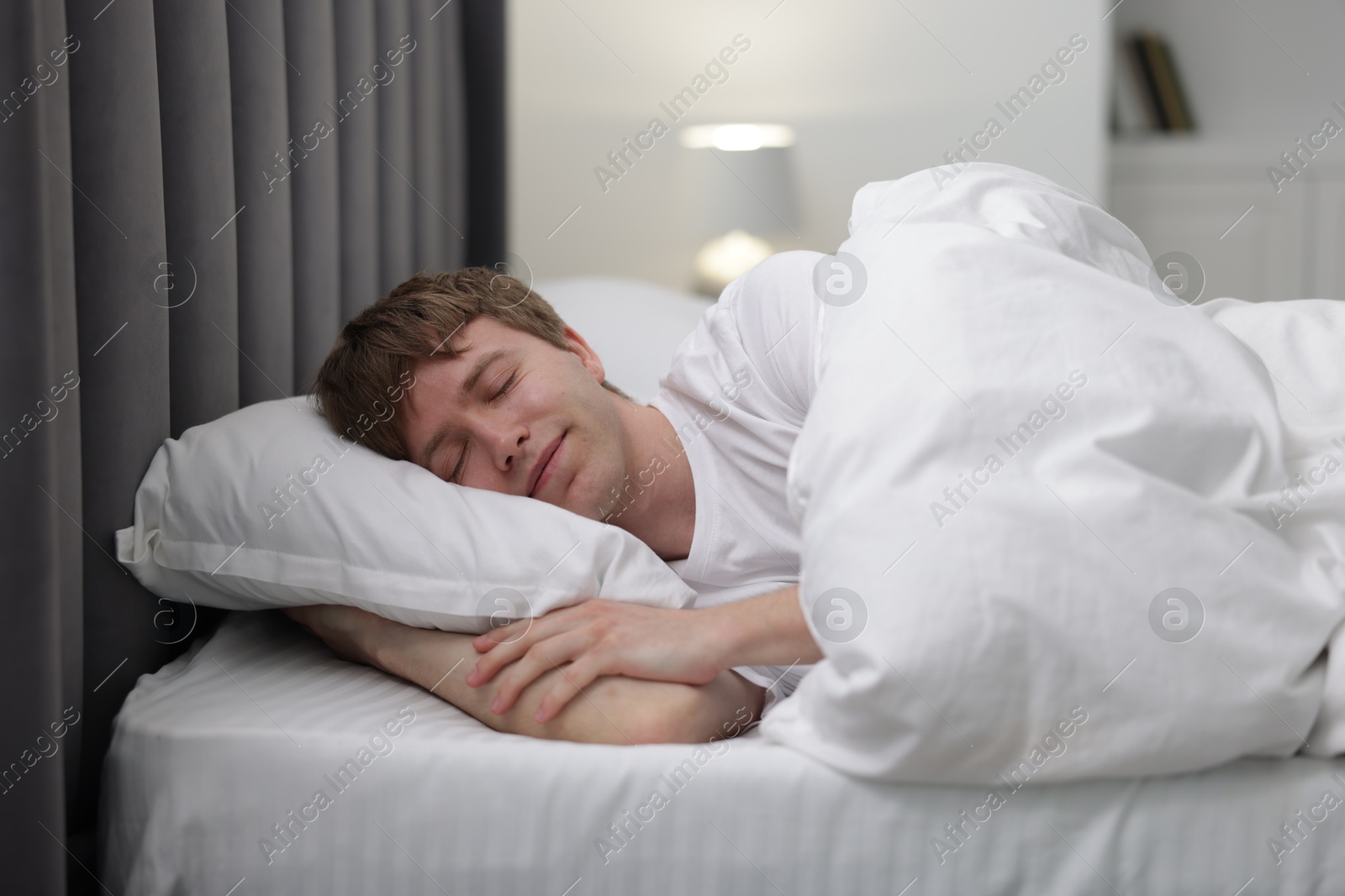Young man sleeping in bed at home Photo of Young man sleeping in bed at home