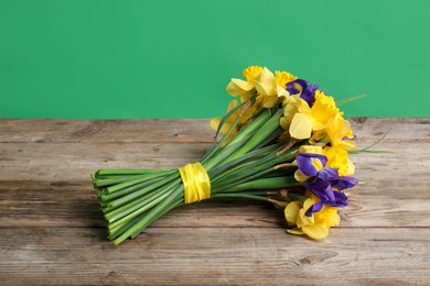 Photo of Bunch of beautiful flowers on wooden table against green background