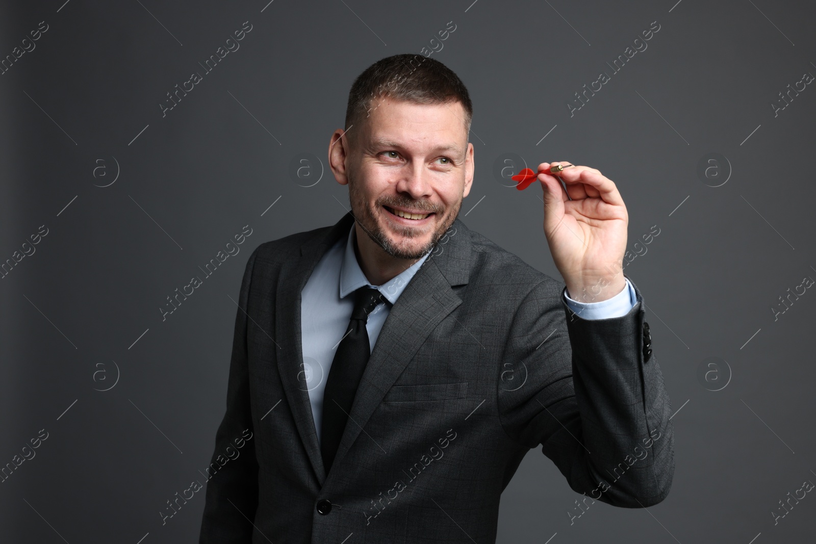 Targeting. Man with dart aiming on grey background Photo of Targeting. Man with dart aiming on grey background