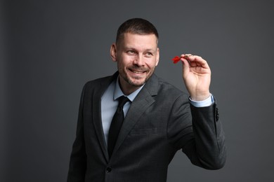Photo of Targeting. Man with dart aiming on grey background