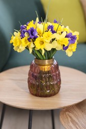 Photo of Bouquet of beautiful flowers in vase on coffee table indoors