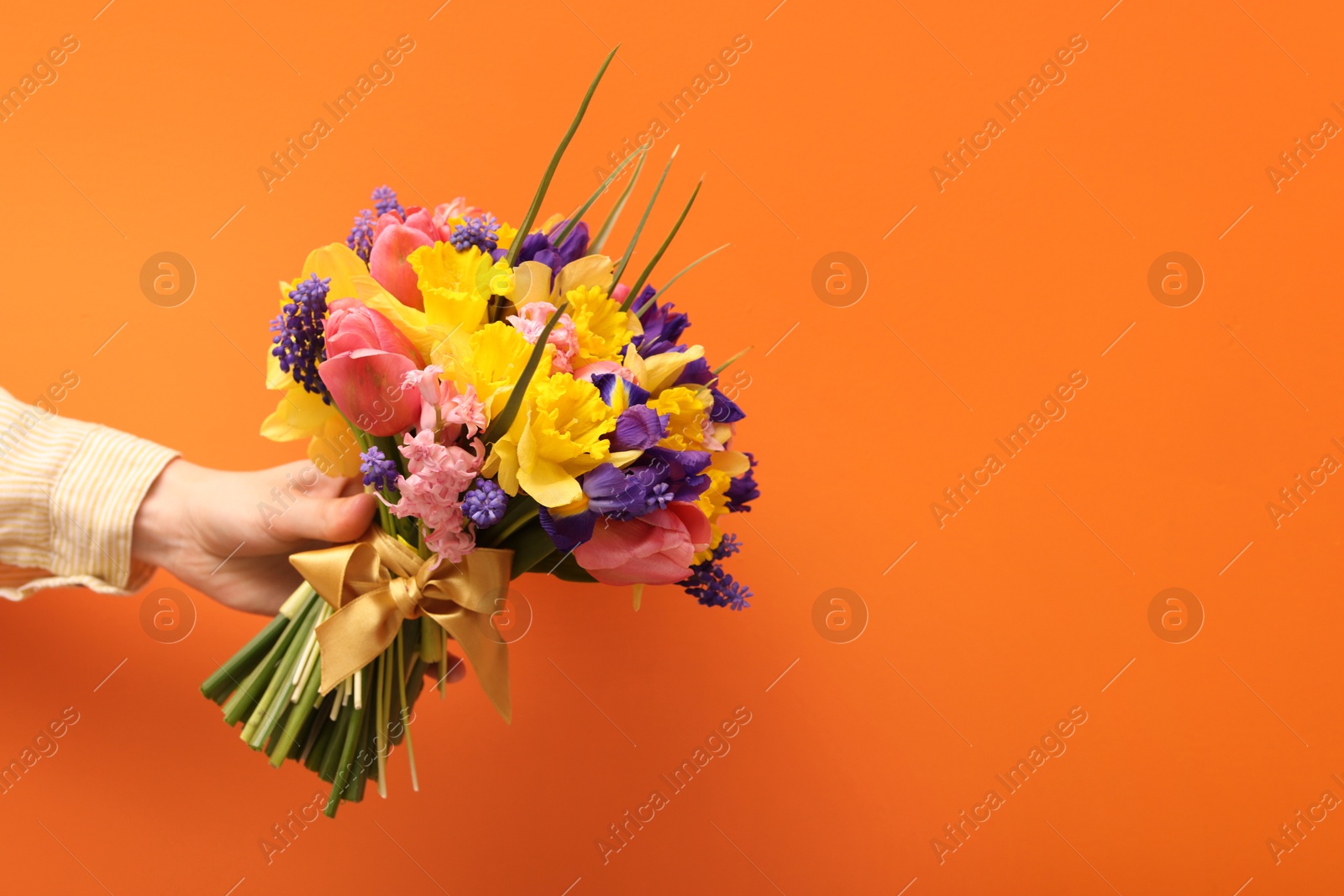 Woman with bouquet of beautiful flowers on orange background, closeup. Space for text Photo of Woman with bouquet of beautiful flowers on orange background, closeup. Space for text