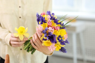 Photo of Woman with bouquet of beautiful flowers indoors, closeup