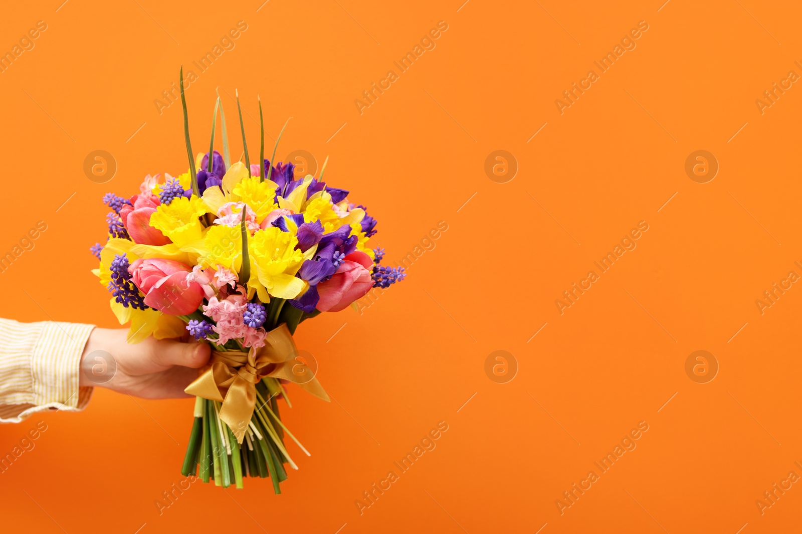 Woman with bouquet of beautiful flowers on orange background, closeup. Space for text Photo of Woman with bouquet of beautiful flowers on orange background, closeup. Space for text