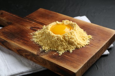 Photo of Corn flour and egg yolk on black textured table, closeup