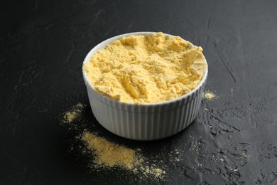 Photo of Corn flour in bowl on black textured table