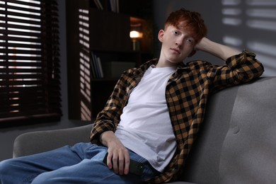 Photo of Teen problems. Depressed teenage boy with smartphone at home, space for text