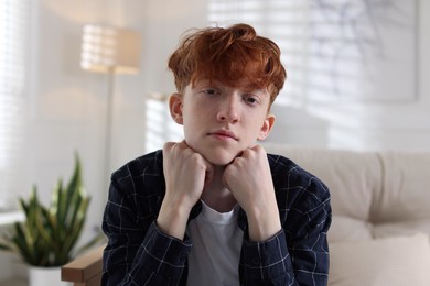 Photo of Teen problems. Depressed teenage boy at home