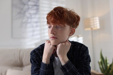 Photo of Teen problems. Depressed teenage boy at home