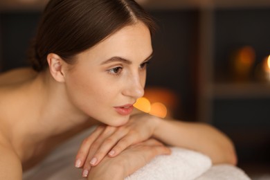 Photo of Beautiful woman relaxing in spa salon, closeup