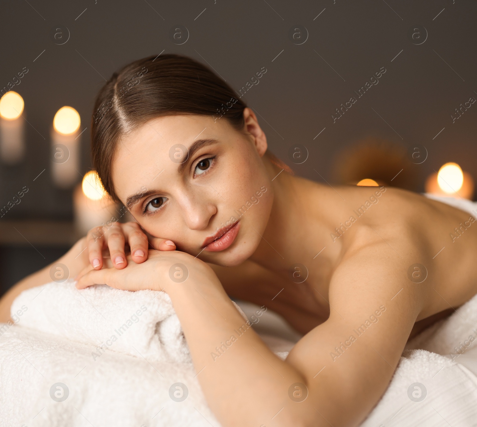 Beautiful woman relaxing on massage couch in spa salon Photo of Beautiful woman relaxing on massage couch in spa salon