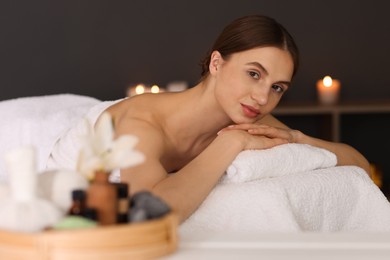 Photo of Beautiful woman relaxing on massage couch in spa salon, selective focus