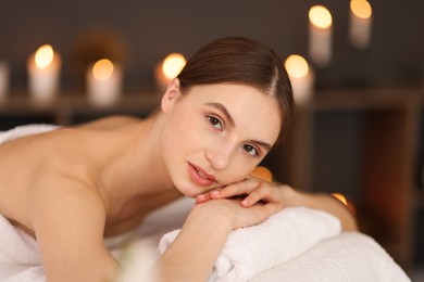 Photo of Beautiful woman relaxing on massage couch in spa salon