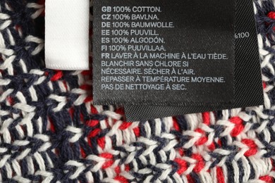 Photo of Clothing label on knitted garment as background, above view