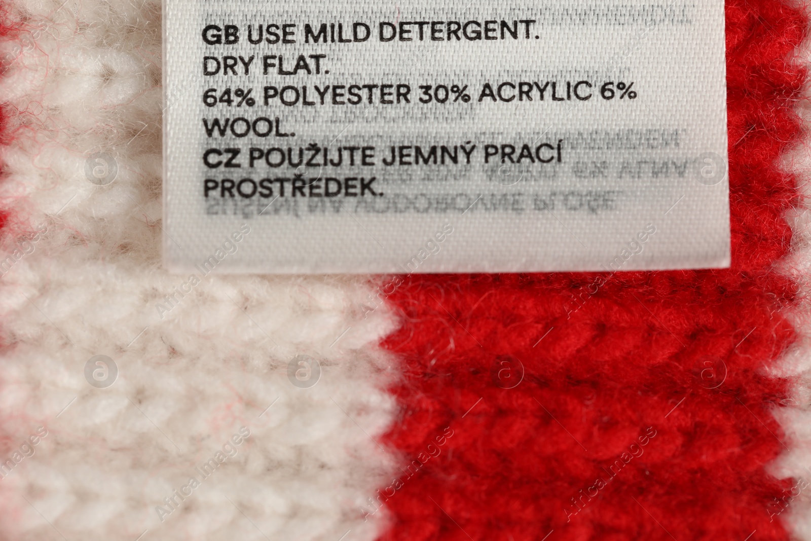 Photo of Clothing label on knitted garment as background, top view