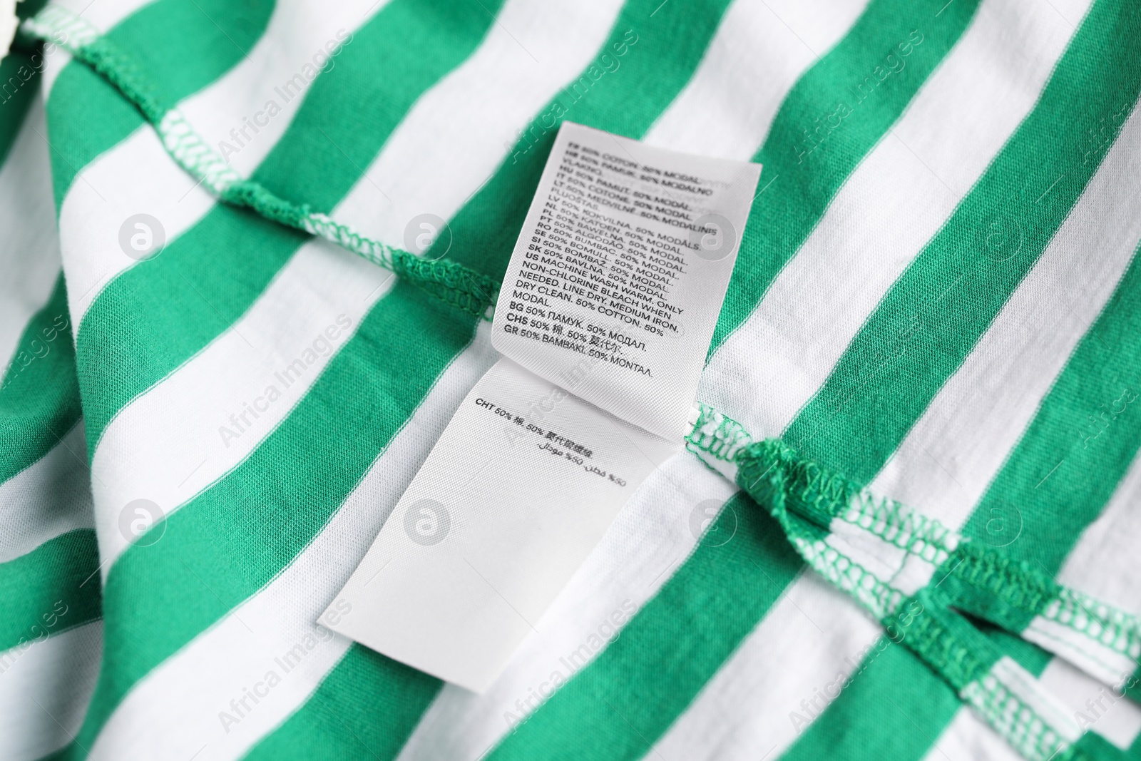 Clothing label on striped garment as background, closeup Photo of Clothing label on striped garment as background, closeup