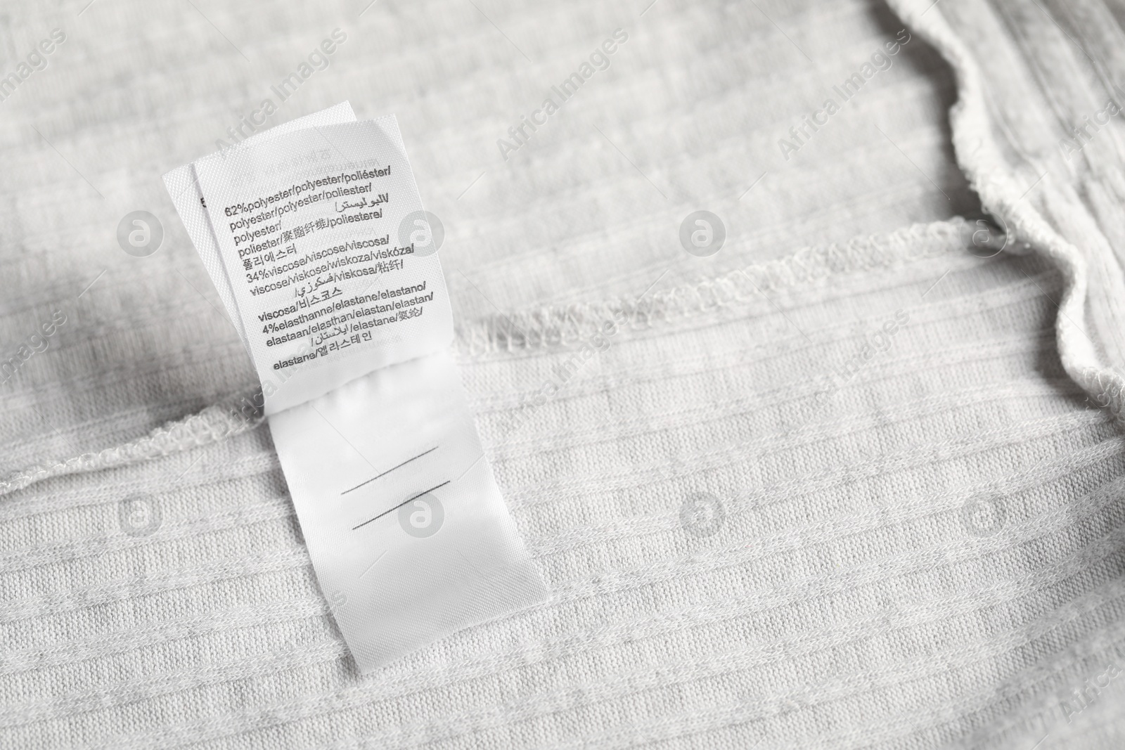 Clothing label on light garment as background, above view Photo of Clothing label on light garment as background, above view
