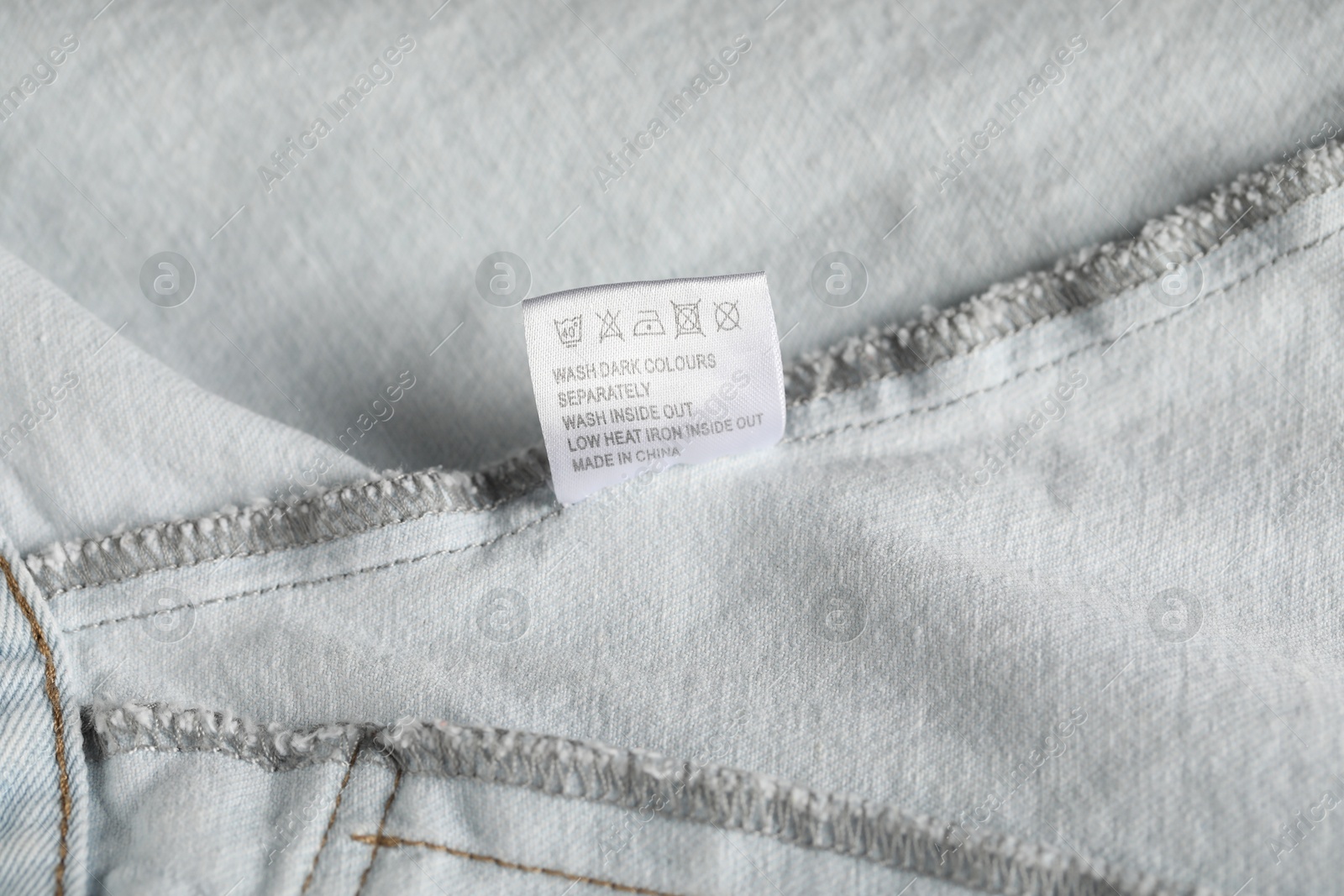 Clothing label with care symbols on garment as background, closeup Photo of Clothing label with care symbols on garment as background, closeup