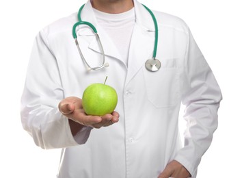 Photo of Nutritionist with green apple and stethoscope on white background, closeup