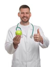 Photo of Nutritionist with green apple and stethoscope showing thumbs up on white background