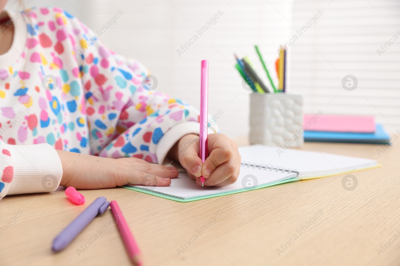 Little girl doing homework at table indoors, closeup Photo of Little girl doing homework at table indoors, closeup