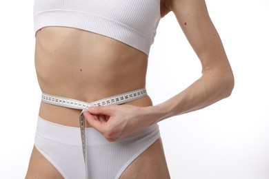 Photo of Woman with slim body and measuring tape on white background, closeup