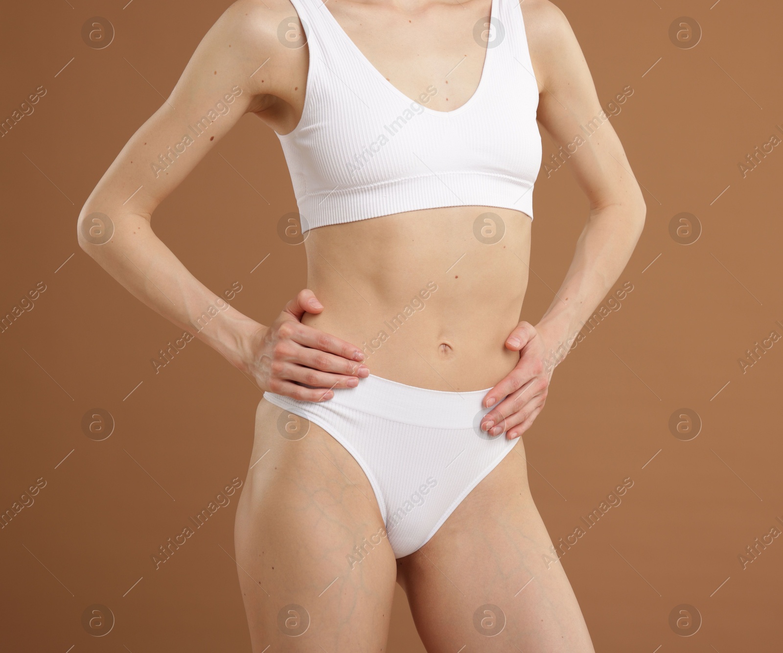 Photo of Woman with perfect slim body on beige background, closeup