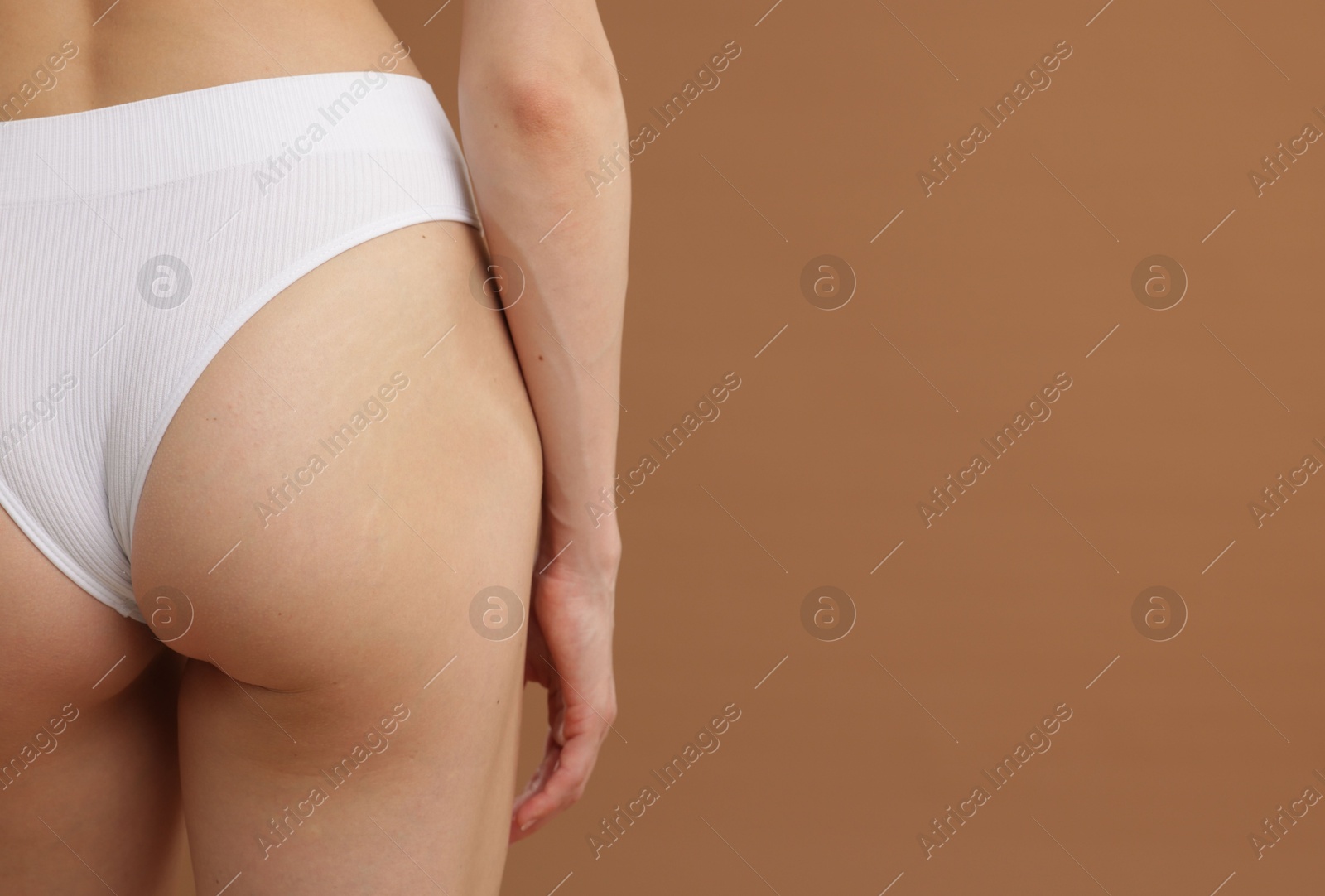 Photo of Woman with perfect slim body on beige background, closeup. Space for text