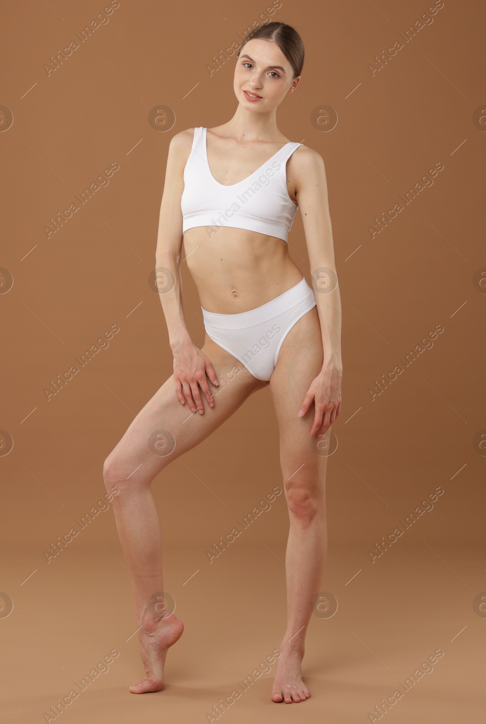 Beautiful woman with perfect slim body on beige background Photo of Beautiful woman with perfect slim body on beige background