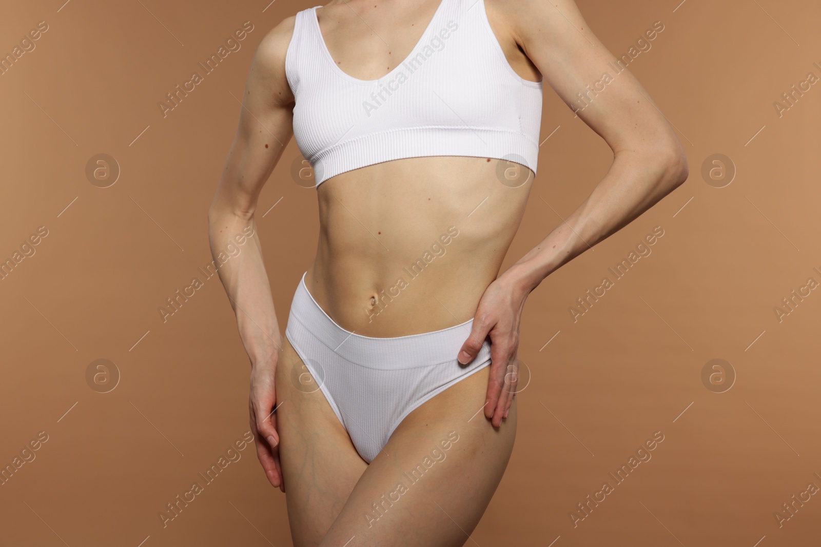 Photo of Woman with perfect slim body on beige background, closeup