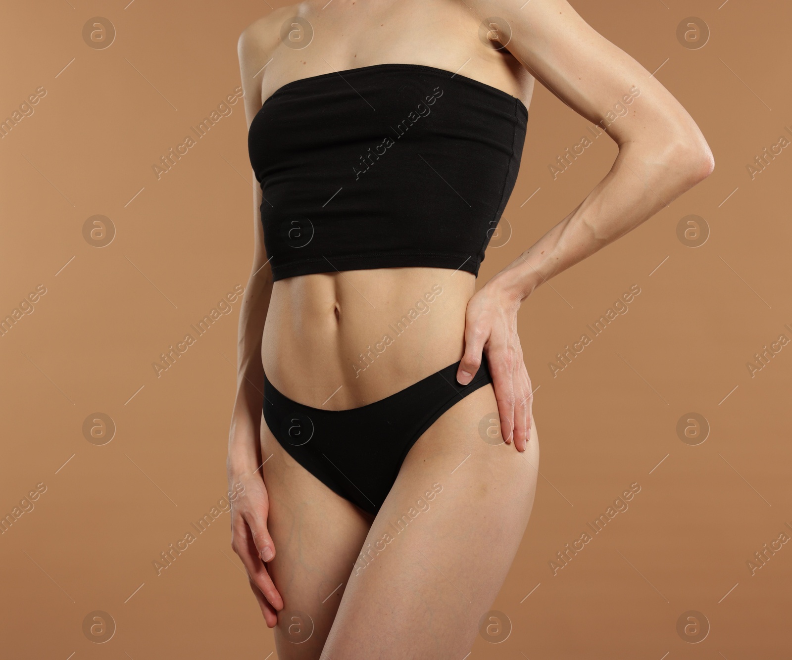 Photo of Woman with perfect slim body on beige background, closeup