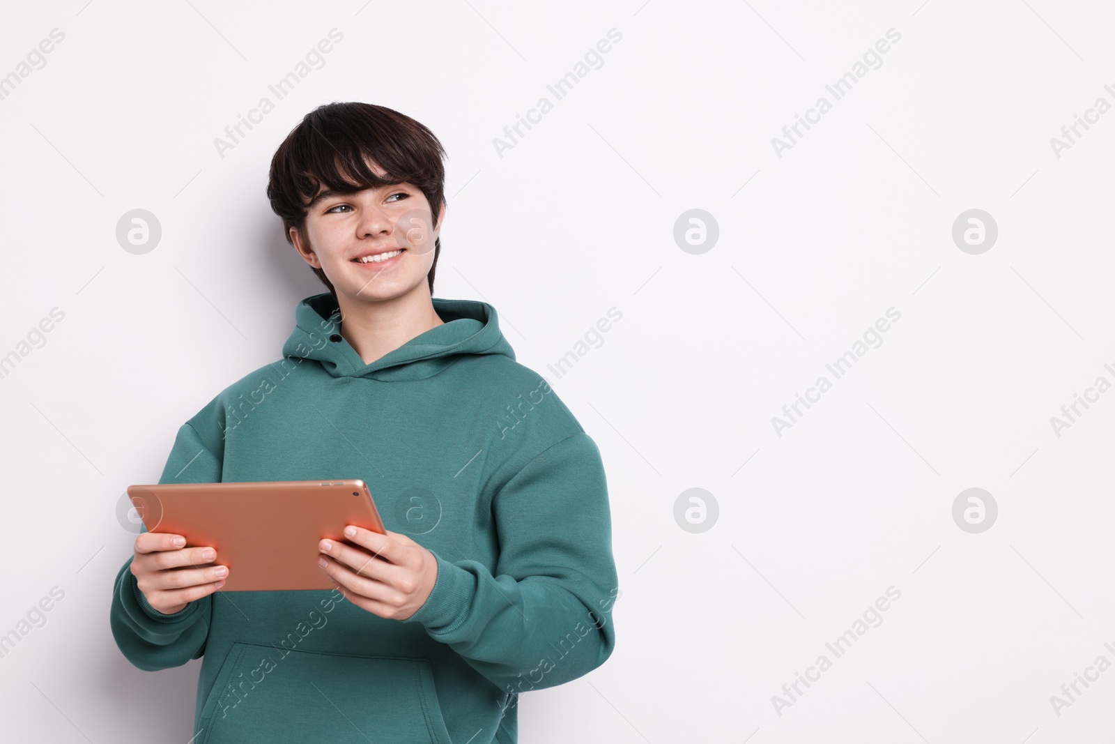 Photo of Teenage boy with tablet on white background, space for text