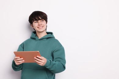 Photo of Teenage boy with tablet on white background, space for text