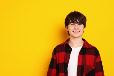 Photo of Portrait of teenage boy on orange background, space for text
