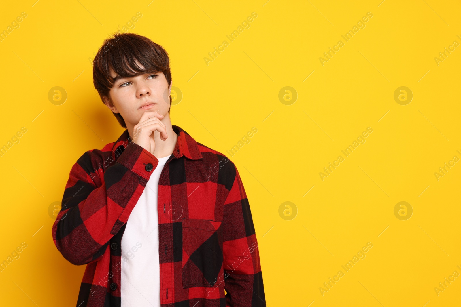 Portrait of teenage boy on orange background, space for text Photo of Portrait of teenage boy on orange background, space for text
