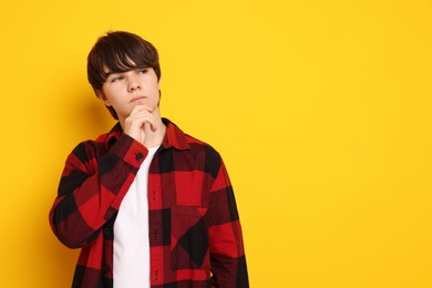 Photo of Portrait of teenage boy on orange background, space for text
