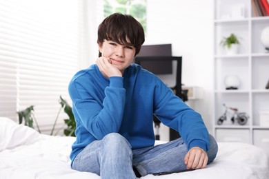 Photo of Portrait of teenage boy on bed at home