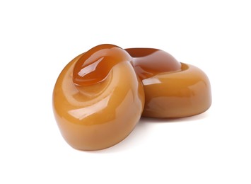 Photo of Tasty sweet candies and caramel sauce isolated on white