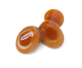 Photo of Tasty sweet candies and caramel sauce isolated on white, top view