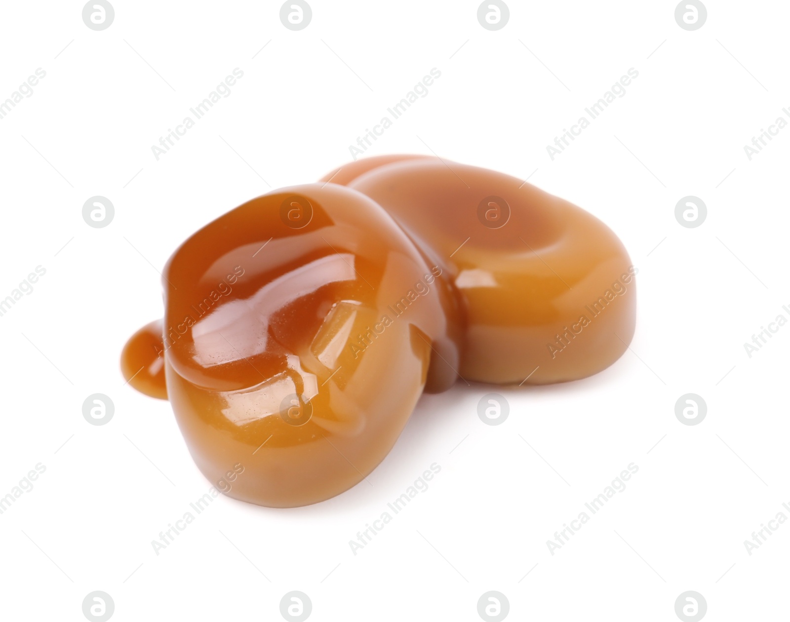 Tasty sweet candies and caramel sauce isolated on white Photo of Tasty sweet candies and caramel sauce isolated on white