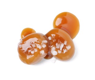 Photo of Tasty sweet candies, salt and caramel sauce isolated on white, top view