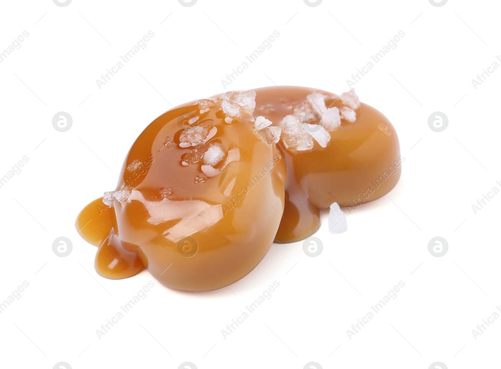 Tasty sweet candies, salt and caramel sauce isolated on white Photo of Tasty sweet candies, salt and caramel sauce isolated on white