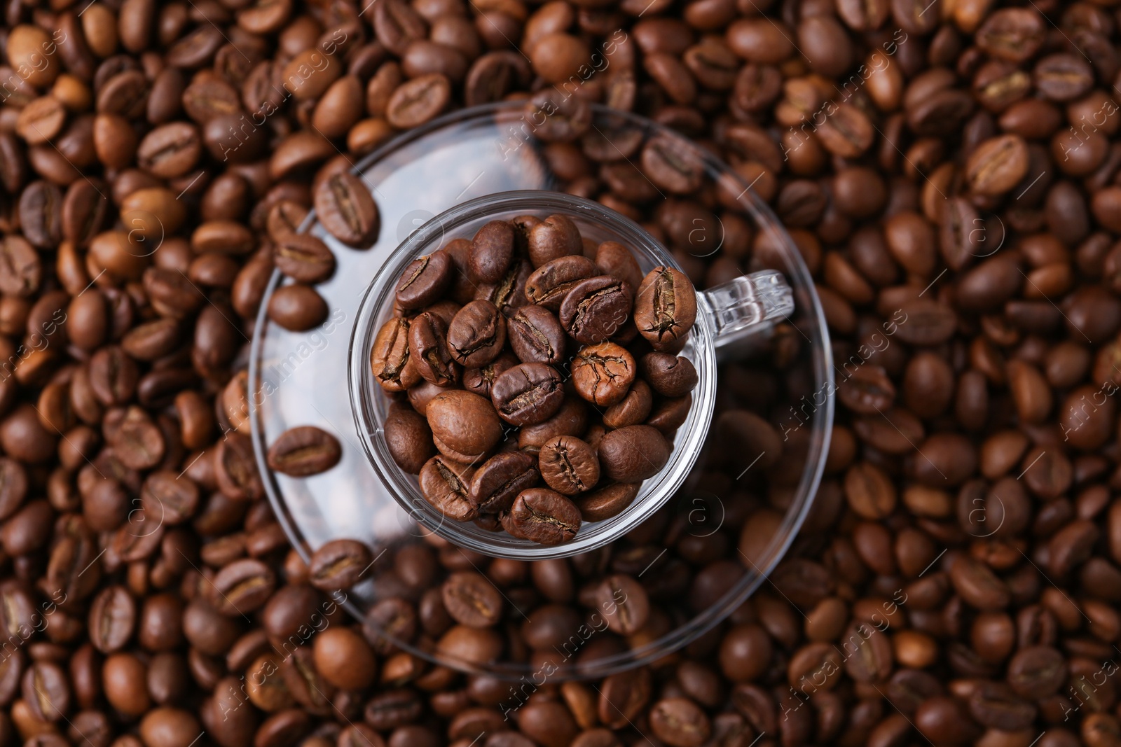 Cup and saucer on coffee beans, top view Photo of Cup and saucer on coffee beans, top view