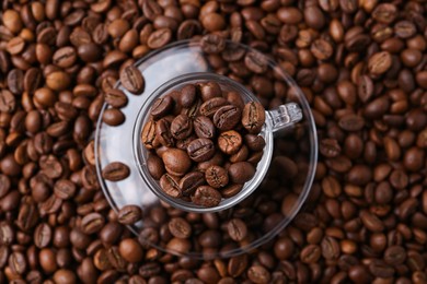 Photo of Cup and saucer on coffee beans, top view