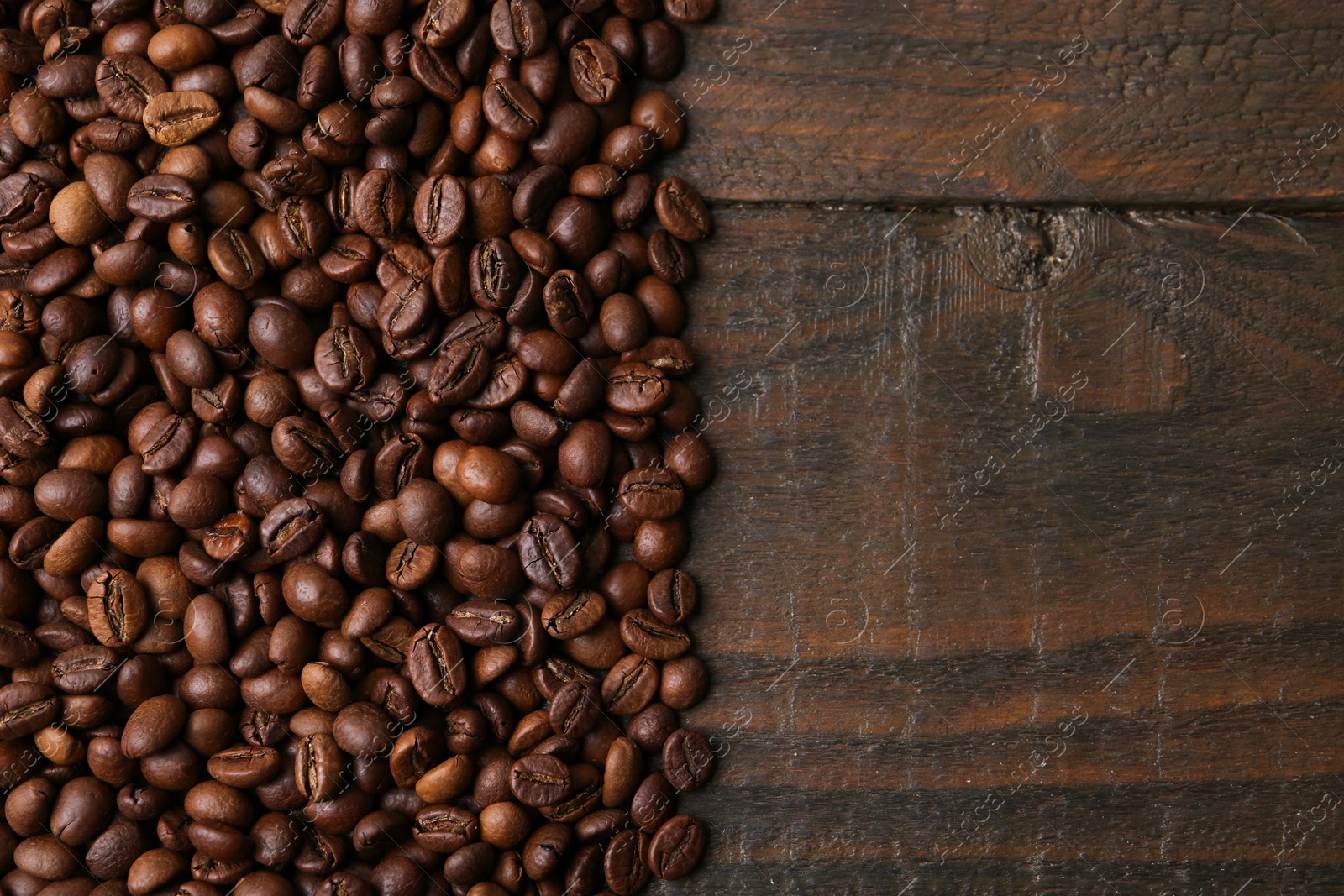 Aromatic coffee beans on wooden table, top view. Space for text Photo of Aromatic coffee beans on wooden table, top view. Space for text