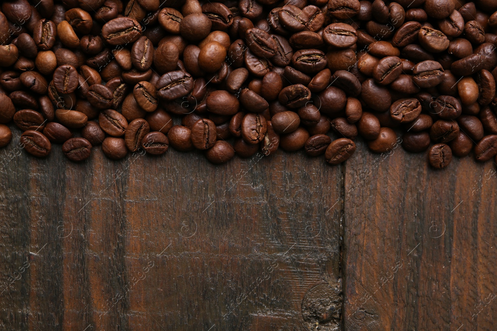 Aromatic coffee beans on wooden table, top view. Space for text Photo of Aromatic coffee beans on wooden table, top view. Space for text