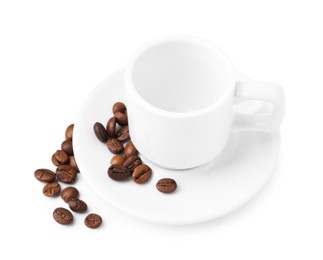 Photo of Aromatic coffee beans, cup and saucer isolated on white