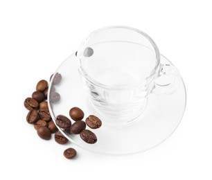 Photo of Aromatic coffee beans, cup and saucer isolated on white
